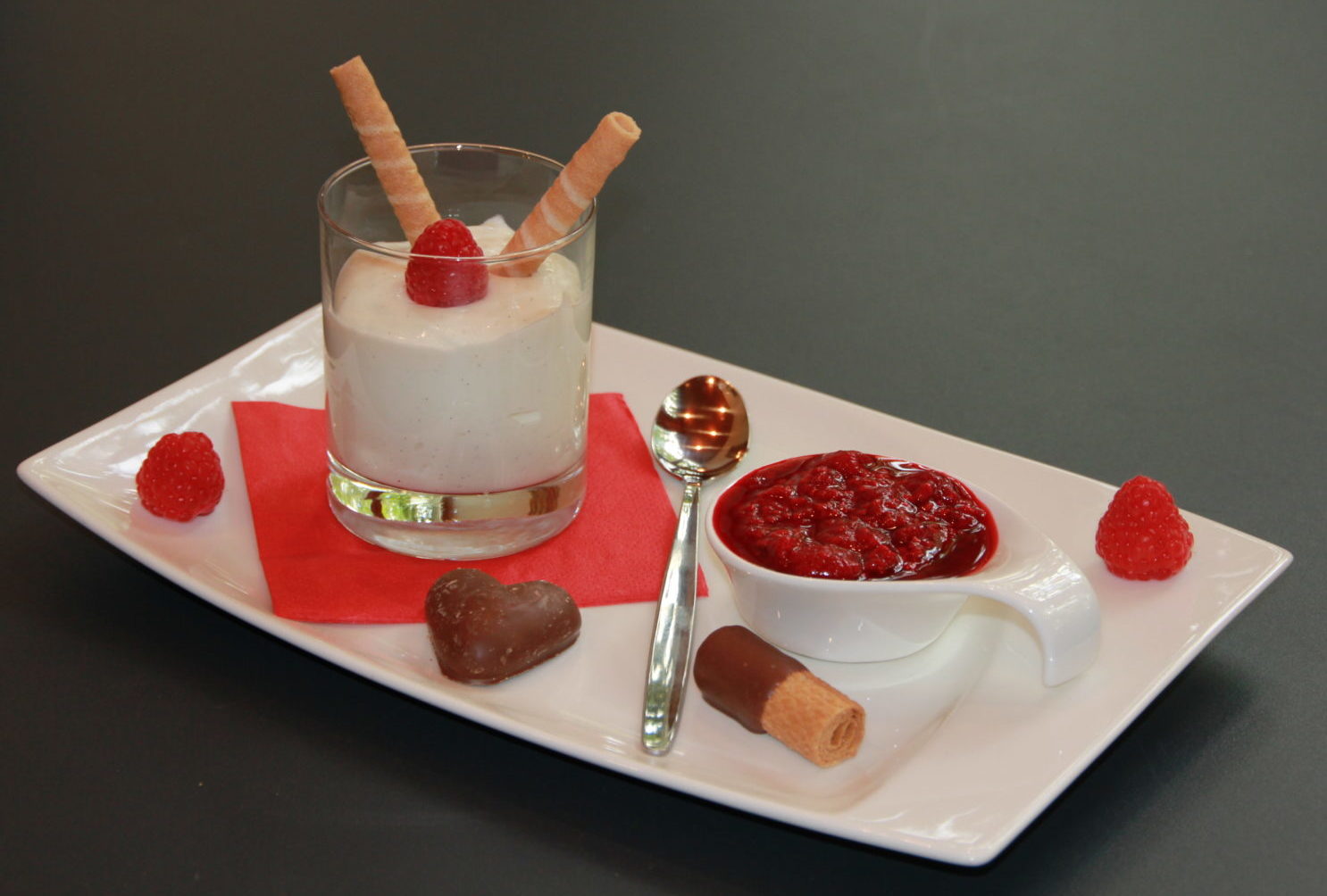 Topfen-Vanille Créme im Glas auf frischen Himbeeren